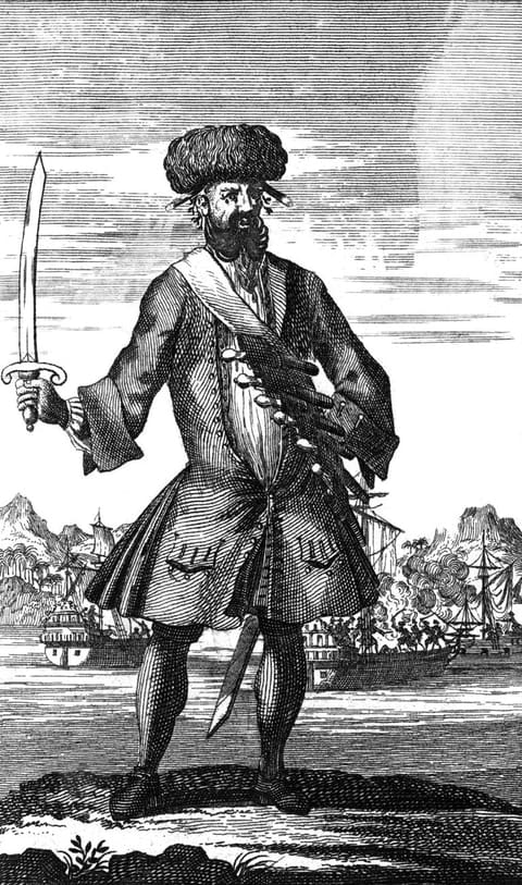 Engraved plate. A full-length figure of a man stands on a shore, sword raised in his right hand, wearing a tall fur cap, a long coat, and a bandolier of pistols slung across his chest, with a heavy black beard spreading over his chest and twists of cord hanging at his ears. Behind him armed sailing ships engage, with smoke of battle rising on the right.